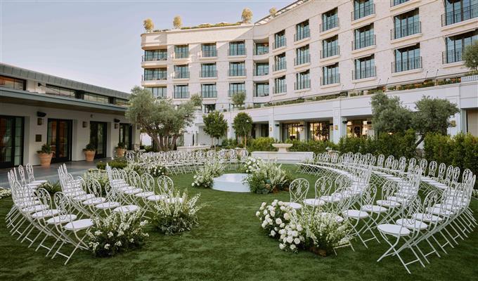 The Lawn with Seating separated by an aisle to walk down in the middle which leads to a building